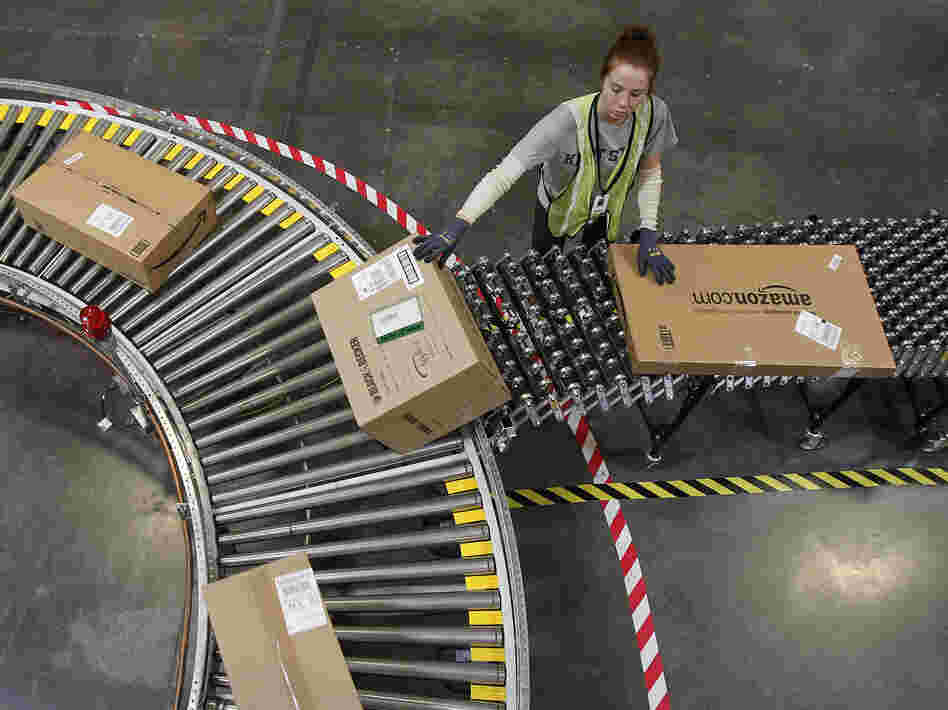 An Amazon worker sorts packages at a fulfillment center in Goodyear, Ariz. An Amazon worker sorts packages at a fulfillment center in Goodyear, Ariz.