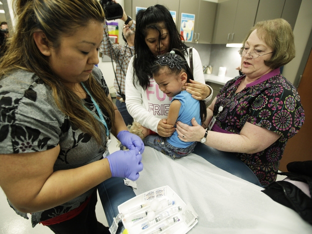 Nurse Fatima Guillen (left) gives 4-year-old Kimberly Magdeleno a whooping cough booster shot at a health clinic in Tacoma, Wash., in May.