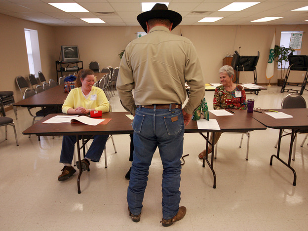 Volunteers check in a voter in Palo Pinto, Texas, in November 2008. The state is using a list from the Social Security Administration to purge dead voters from its election rolls.