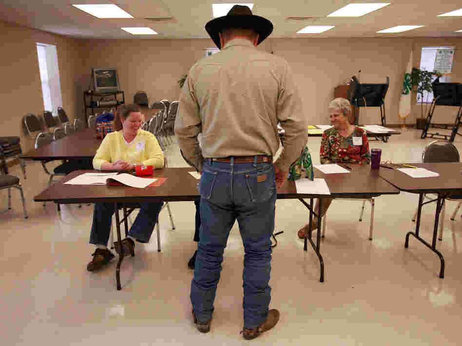 Volunteers check in a voter in Palo Pinto, Texas, in November 2008. The state is using a list from the Social Security Administration to purge dead voters from its election rolls.