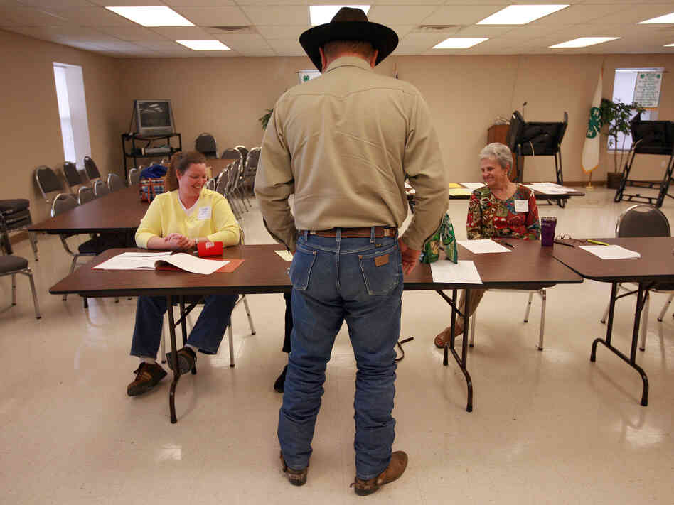 Volunteers check in a voter in Palo Pinto, Texas, in November 2008. The state is using a list from the Social Security Administration to purge dead voters from its election rolls.