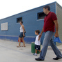 Parents take their children to School No. 103 on the first day of the new school year in Valencia, Spain, on Sept. 7. Spanish students, parents and teachers are feeling the pinch of the ongoing European debt crisis.
