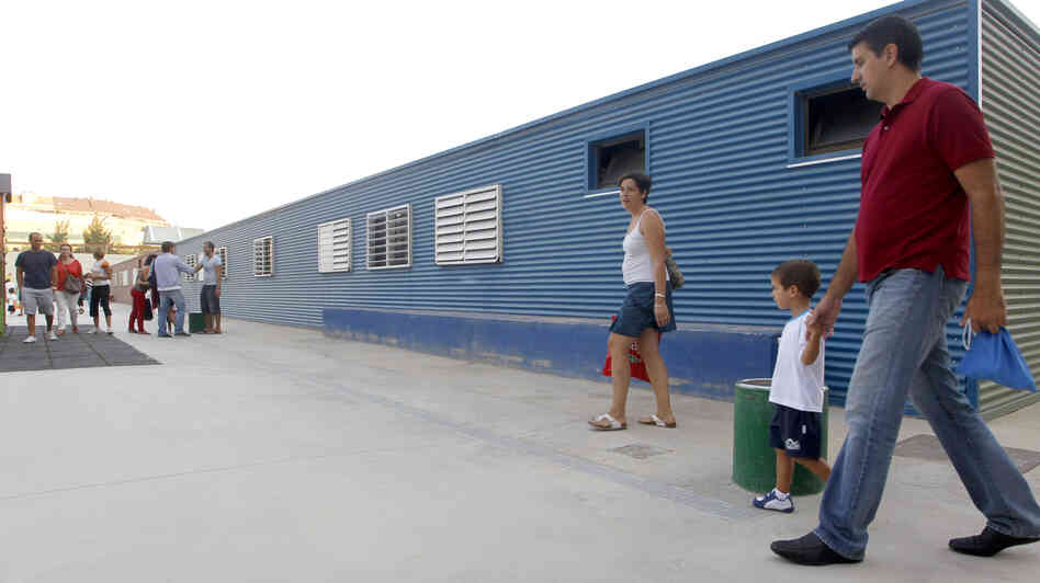 Parents take their children to School No. 103 on the first day of the new school year in Valencia, Spain, on Sept. 7. Spanish students, parents and teachers are feeling the pinch of the ongoing European debt crisis.