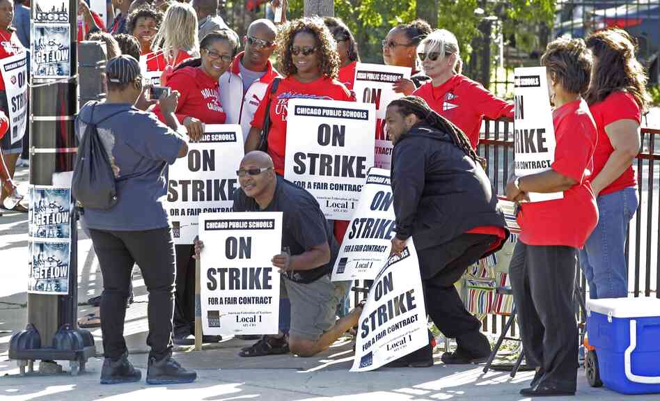 Chicago public school teachers pose for a photo on a picket line as their strike extends into a fifth day.