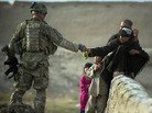 A U.S. soldier shares grapes with Afghan boys in the southern province of Kandahar on Wednesday. A U.S. soldier shares grapes with Afghan boys in the southern province of Kandahar on Wednesday.