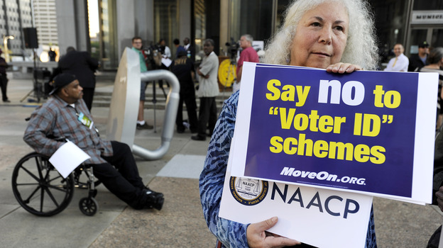 Gloria Gilman holds a sign Thursday in Philadelphia  during the NAACP voter ID rally to demonstrate her opposition to Pennsylvania's new voter identification law.