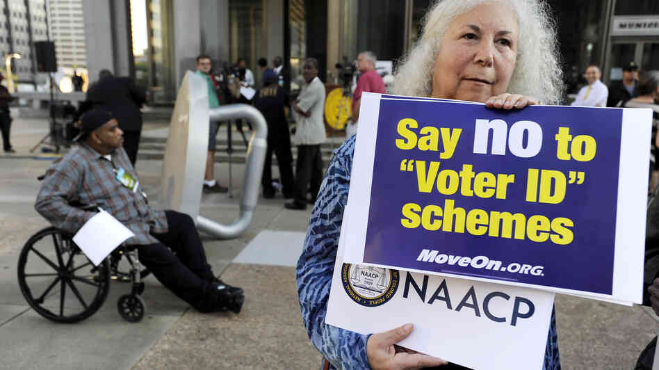 Gloria Gilman holds a sign Thursday in Philadelphia  during the NAACP voter ID rally to demonstrate her opposition to Pennsylvania's new voter identification law.