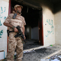 A Libyan military guard stands in front of one of the U.S. Consulate's burnt-out buildings in Benghazi Sept. 14 during the visit of President Mohammed el-Megarif.
