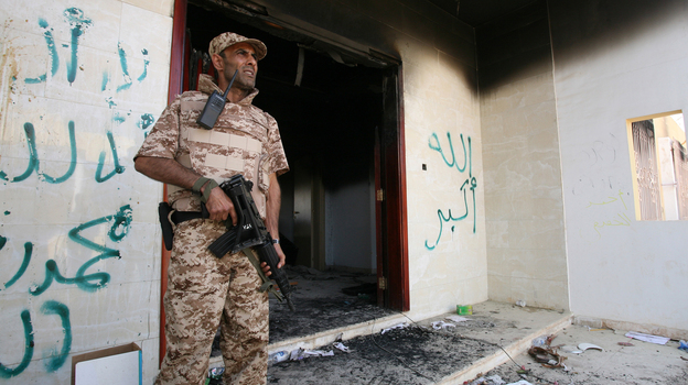 A Libyan military guard stands in front of one of the U.S. Consulate's burnt-out buildings in Benghazi Sept. 14 during the visit of President Mohammed el-Megarif.