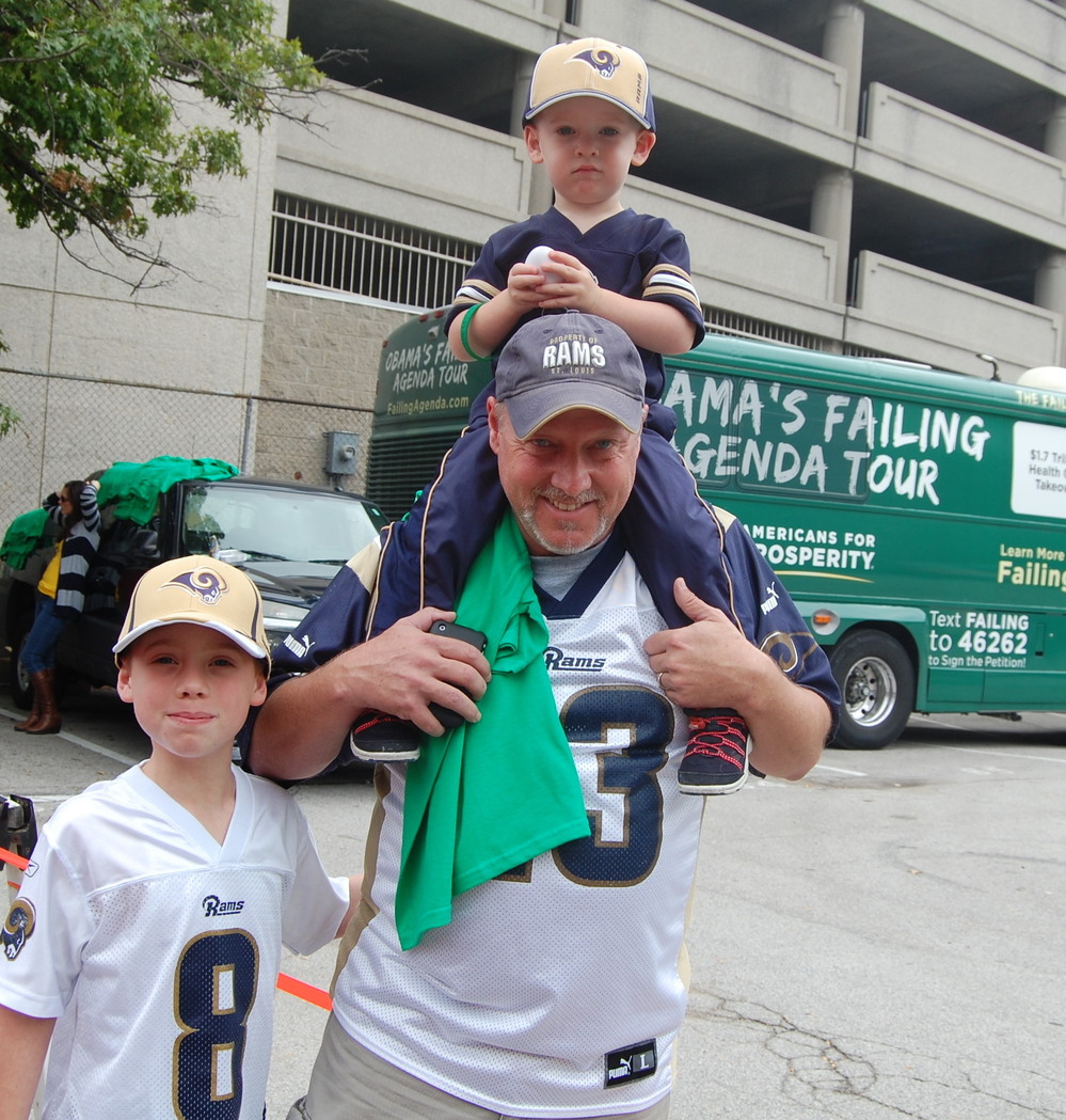 Rowdy Smith, who brought his sons to the St. Louis Rams game on Sunday, said that President Obama's "not a leader" and is hurting the energy industry. He's shown here walking in front of the Americans for Prosperity campaign bus.