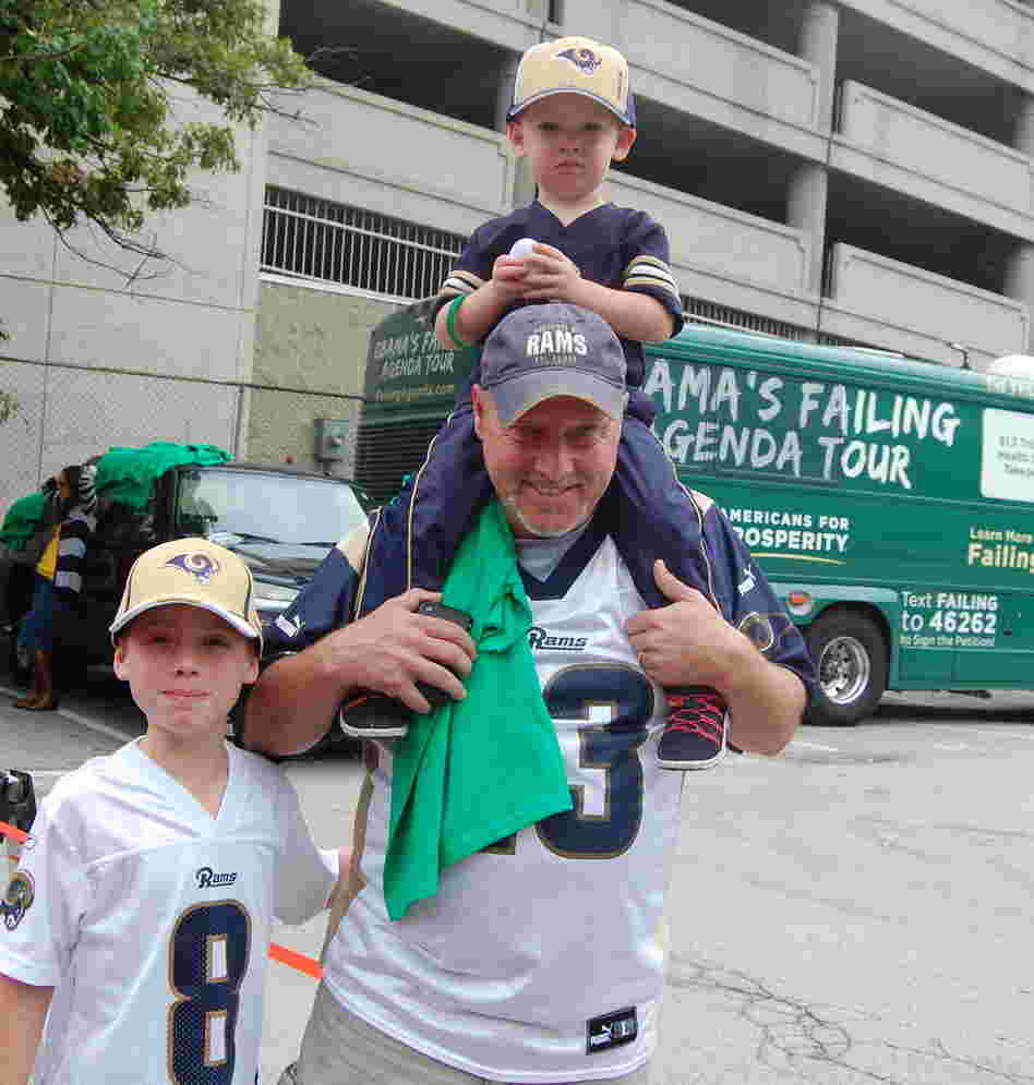 Rowdy Smith, who brought his sons to the St. Louis Rams game on Sunday, said that President Obama's "not a leader" and is hurting the energy industry. He's shown here walking in front of the Americans for Prosperity campaign bus.