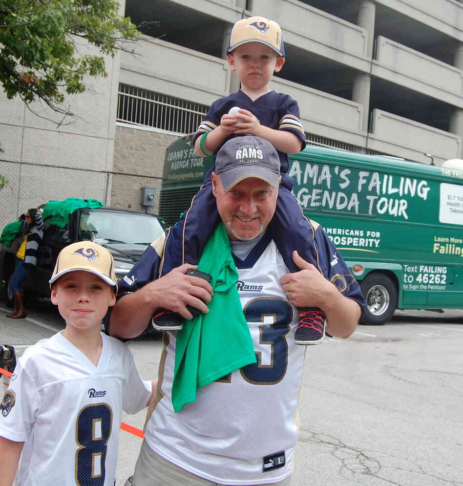 Rowdy Smith, who brought his sons to the St. Louis Rams game on Sunday, said that President Obama's "not a leader" and is hurting the energy industry. He's shown here walking in front of the Americans for Prosperity campaign bus.