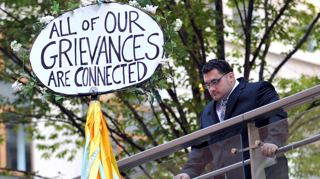 A man looks down at a sign during the Occupy Wall Street protest on the one year anniversary of the movement in New York.