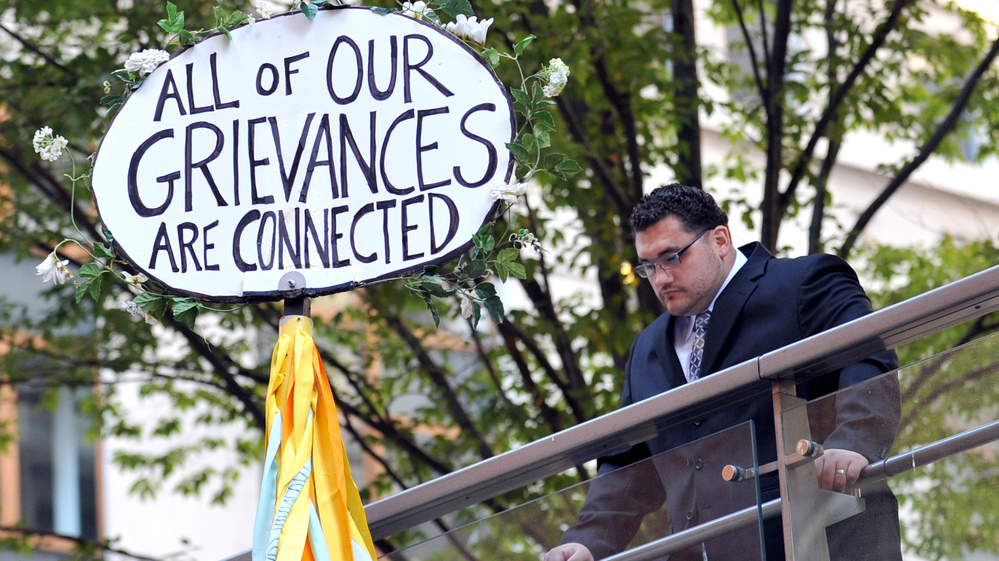 A man looks down at a sign during the Occupy Wall Street protest on the one year anniversary of the movement in New York.