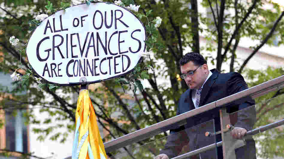 A man looks down at a sign during the Occupy Wall Street protest on the one year anniversary of the movement in New York.
