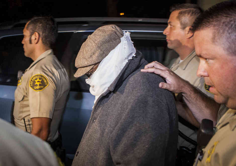 Los Angles County Sheriff's officers escort an unidentified person out of Nakoula Basseley Nakoula's home in Cerritos, Calif., early Saturday.