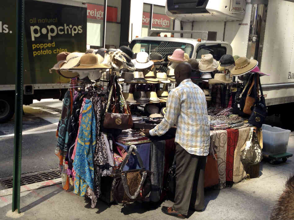 Cheikh Fall sets up his stall. He lives by the motto, "Work like you're never gonna die, and worship like you will die tomorrow."