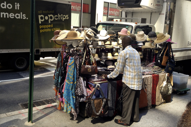 Cheikh Fall sets up his stall. He lives by the motto, "Work like you're never gonna die, and worship like you will die tomorrow."