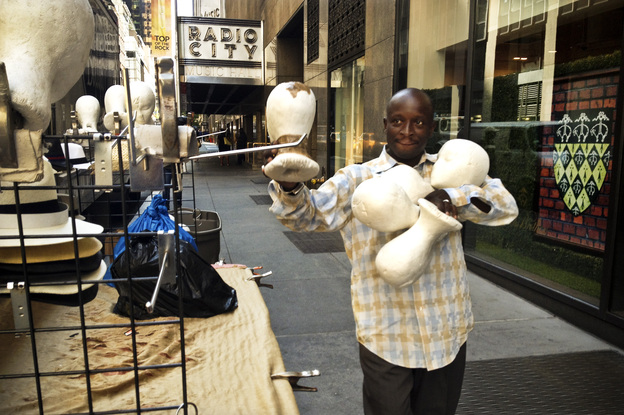 Senegalese vendor Cheikh Fall prepares his stall in front of Brooks Brothers on 51st Street, just off the Avenue of the Americas in New York City. Fall runs an association of Senegalese vendors that deals with the city over licensing and regulations.