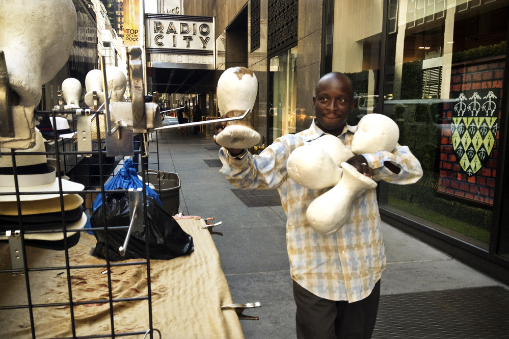 Senegalese vendor Cheikh Fall prepares his stall in front of Brooks Brothers on 51st Street, just off the Avenue of the Americas in New York City. Fall runs an association of Senegalese vendors that deals with the city over licensing and regulations.
