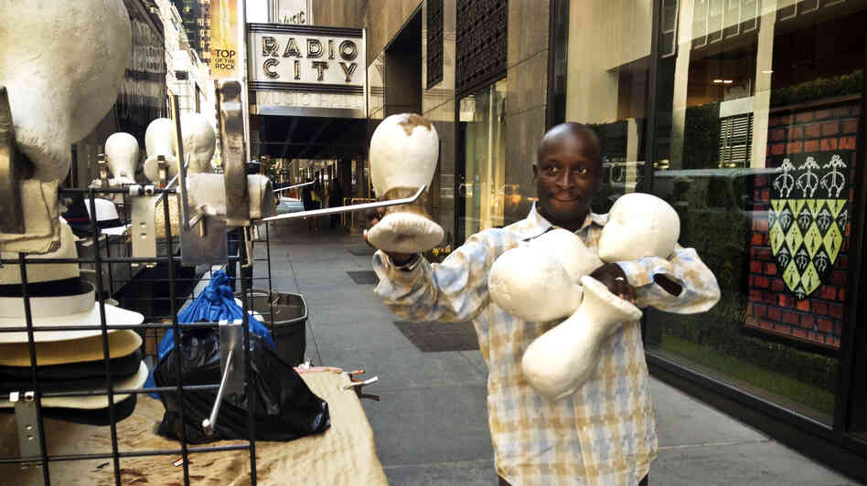 Senegalese vendor Cheikh Fall prepares his stall in front of Brooks Brothers on 51st Street, just off the Avenue of the Americas in New York City. Fall runs an association of Senegalese vendors that deals with the city over licensing and regulations.