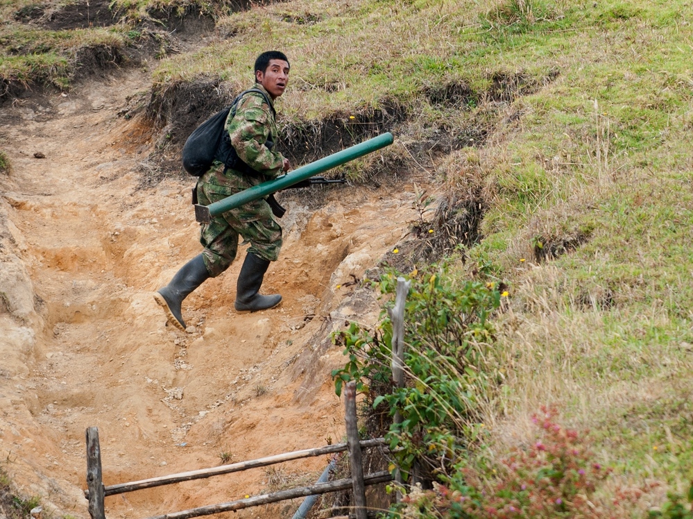 A member of the Revolutionary Armed Forces of Colombia, or FARC, runs to take position during a firefight with the Colombian army in the mountains of Cauca state on July 12. For now, fighting continues even as the two sides prepare for peace talks.