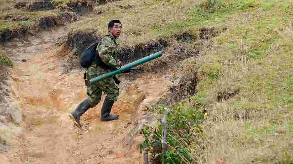 A member of the Revolutionary Armed Forces of Colombia, or FARC, runs to take position during a firefight with the Colombian army in the mountains of Cauca state on July 12. For now, fighting continues even as the two sides prepare for peace talks.