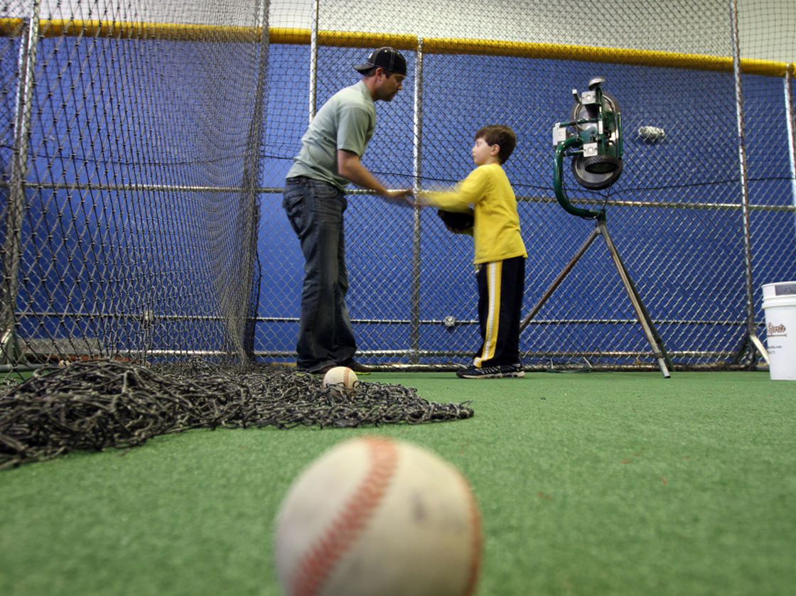 Minor league baseball player Reid Gorecki gives a young player instructions at a training center on Long Island, N.Y.