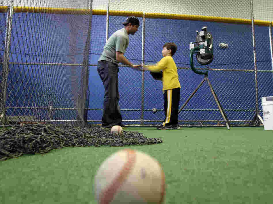 Minor league baseball player Reid Gorecki gives a young player instructions at a training center on Long Island, N.Y.