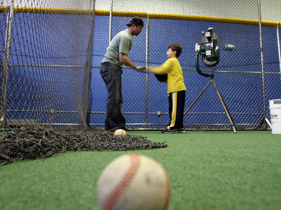 Minor league baseball player Reid Gorecki gives a young player instructions at a training center on Long Island, N.Y.