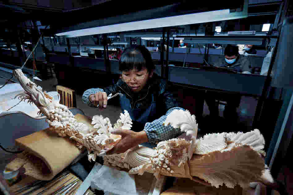 "A worker in China's largest ivory-carving factory finishes a piece symbolizing prosperity. China legally bought 73 tons of ivory from Africa in 2008; since then, poaching and smuggling have both soared."