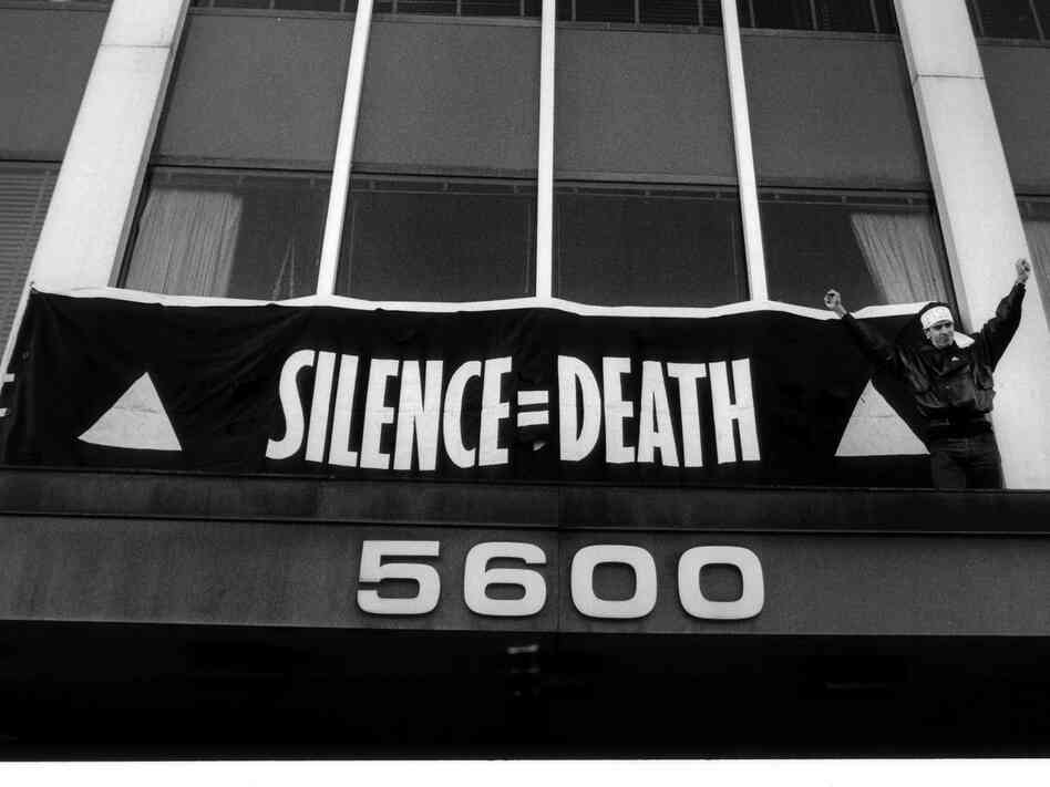 Staley hangs a banner bearing ACT UP's signature "Silence = Death" slogan over the main entrance of FDA headquarters in October 1988.