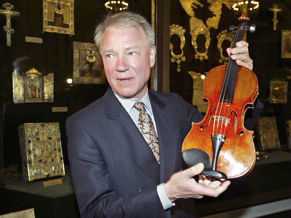 Con man/violin dealer Dietmar Machold holds a (purported) Strad in Moscow in 2003.