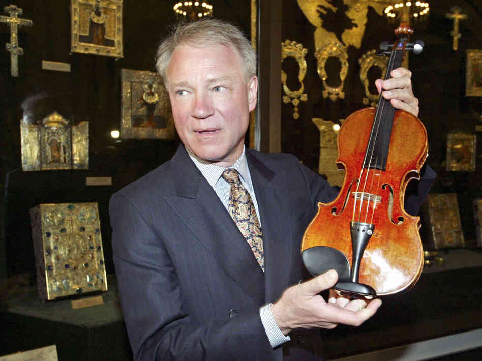 Con man/violin dealer Dietmar Machold holds a (purported) Strad in Moscow in 2003.