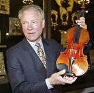 Con man/violin dealer Dietmar Machold holds a (purported) Strad in Moscow in 2003.