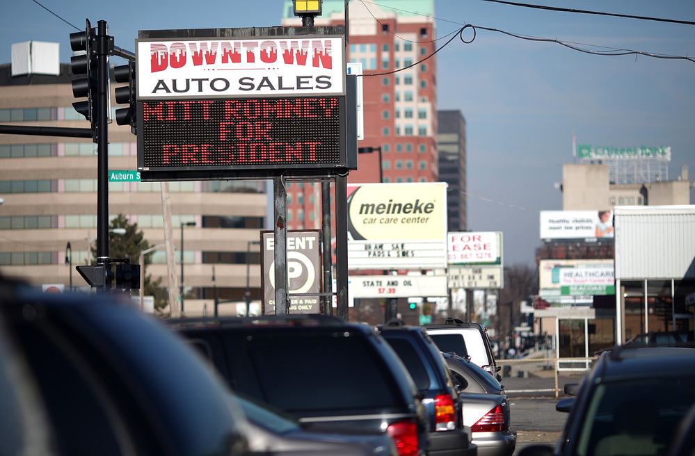 A used-car lot displays a sign in support of Republican presidential candidate Mitt Romney in Manchester, N.H., in January.