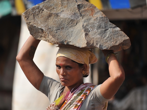 An Indian woman labourer carries a stone on her head at a construction site in Mumbai on Feburary 5, 2011.