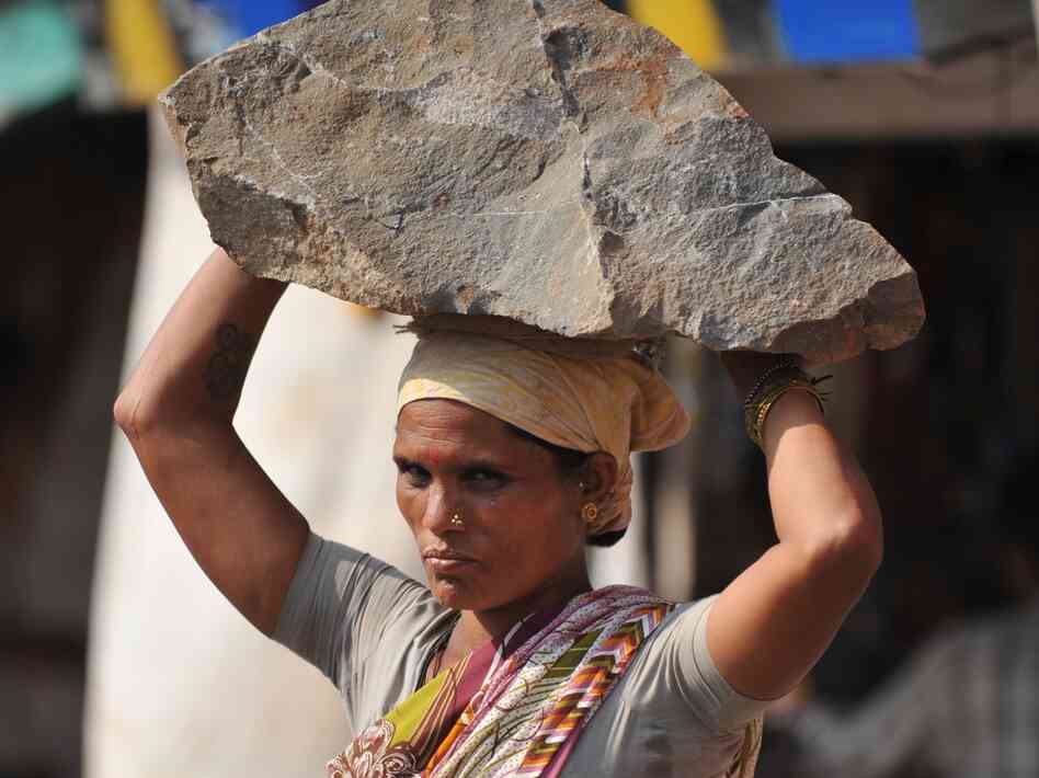 An Indian woman labourer carries a stone on her head at a construction site in Mumbai on Feburary 5, 2011.