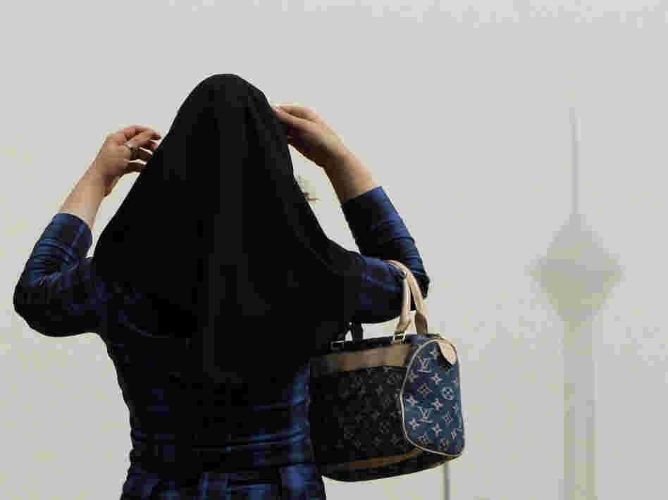 In Tehran, a woman adjusts her headscarf.