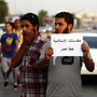 A Libyan follower of Ansar al-Sharia Brigades carries a placard reads in Arabic "our Islamic holies are red line," during a protest in front of the Tibesti Hotel, in Benghazi, Libya, on Sept. 14, as part of widespread anger across the Muslim world about a film ridiculing Islam's Prophet Muhammad.