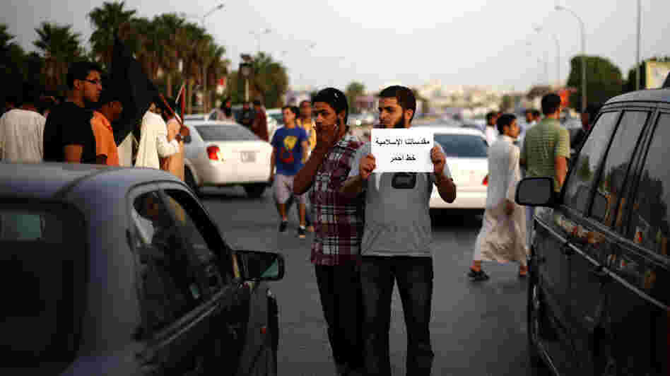 A Libyan follower of Ansar al-Sharia Brigades carries a placard reads in Arabic "our Islamic holies are red line," during a protest in front of the Tibesti Hotel, in Benghazi, Libya, on Sept. 14, as part of widespread anger across the Muslim world about a film ridiculing Islam's Prophet Muhammad.