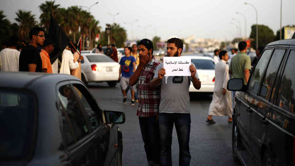 A Libyan follower of Ansar al-Sharia Brigades carries a placard reads in Arabic "our Islamic holies are red line," during a protest in front of the Tibesti Hotel, in Benghazi, Libya, on Sept. 14, as part of widespread anger across the Muslim world about a film ridiculing Islam's Prophet Muhammad.
