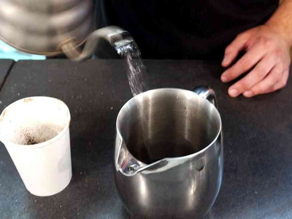 Andrew Shields, a barista at Chinatown Coffee, makes a custom cup of civet coffee, following the instructions to use a French press.