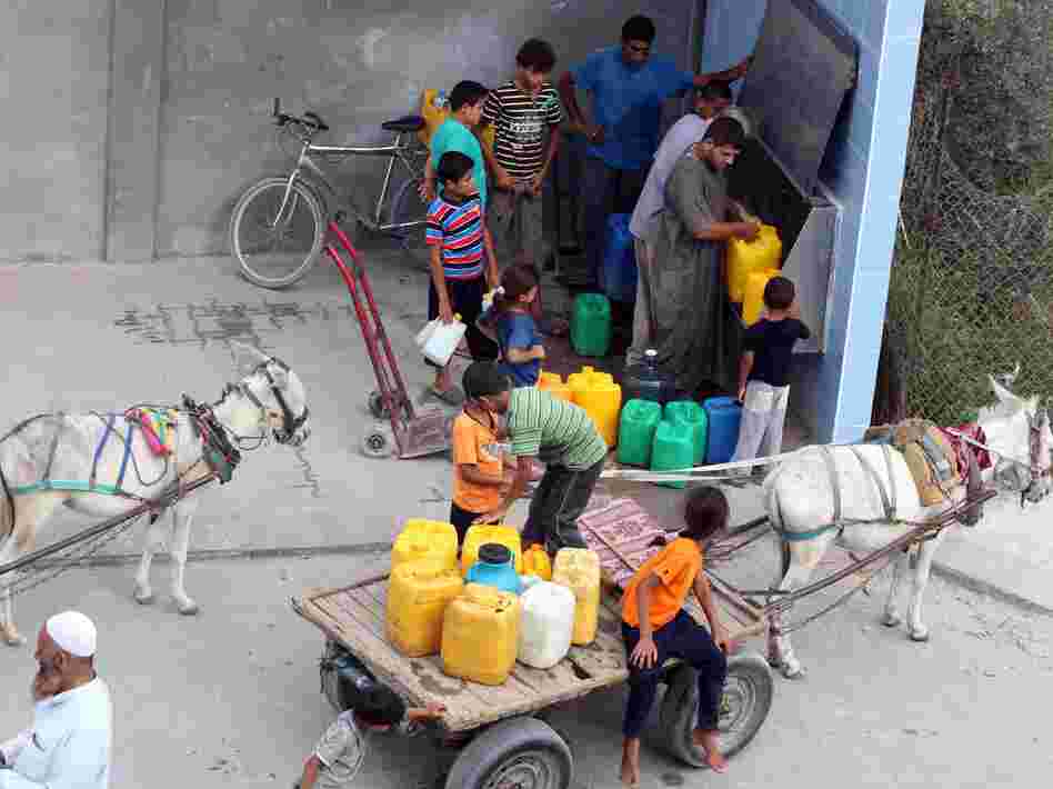 Palestinians fill their bottles with potable water at a water purification station in Deir al-Balah, central Gaza Strip, in July. About 95 percent of the municipal water is undrinkable, and only about 40 percent of homes have access to potable water on a regular basis.