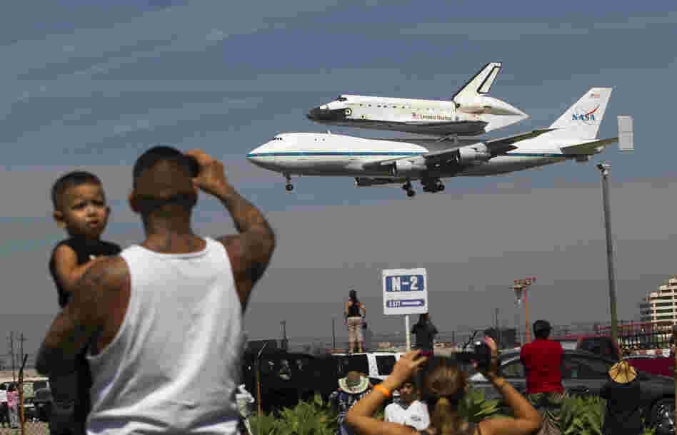 Spectators Mario Vasquez of Redondo Beach and his son Mario Jr., 2, watch as Endeavour prepares to land at Los Angeles International Airport Friday. In a few weeks, the shuttle will travel through the city's streets to its new home at the California Science Center.