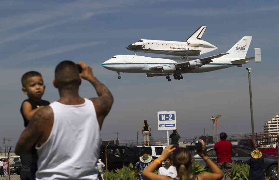 Spectators Mario Vasquez of Redondo Beach and his son Mario Jr., 2, watch as Endeavour prepares to land at Los Angeles International Airport Friday. In a few weeks, the shuttle will travel through the city's streets to its new home at the California Science Center.