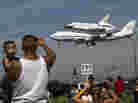 Spectators Mario Vasquez, 40, of Redondo Beach and his son Mario Jr., 2, watch as space shuttle Endeavour, atop NASA's Shuttle Carrier Aircraft, prepares to land at Los Angeles International Airport Friday.