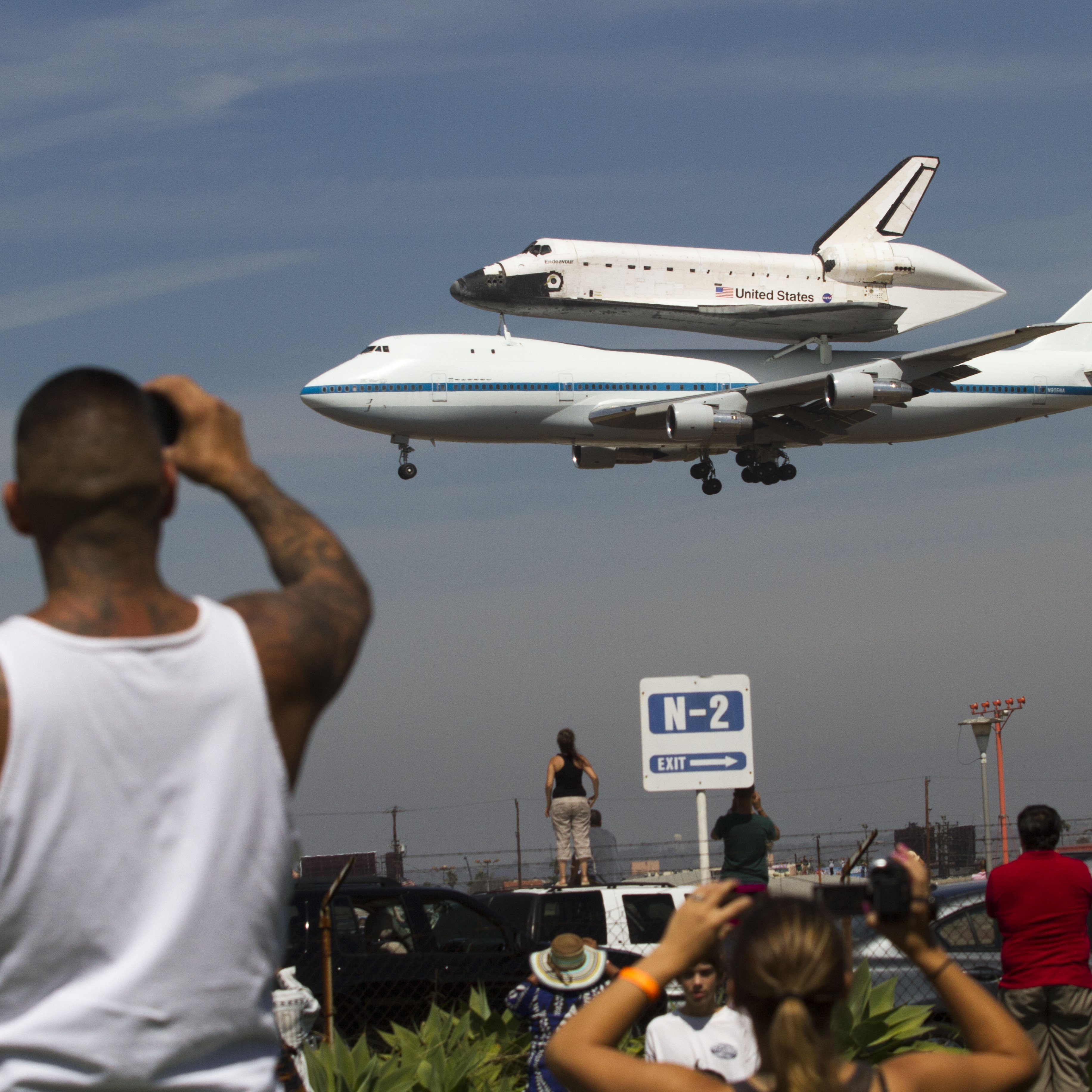 Spectators Mario Vasquez, 40, of Redondo Beach and his son Mario Jr., 2, watch as space shuttle Endeavour, atop NASA's Shuttle Carrier Aircraft, prepares to land at Los Angeles International Airport Friday.