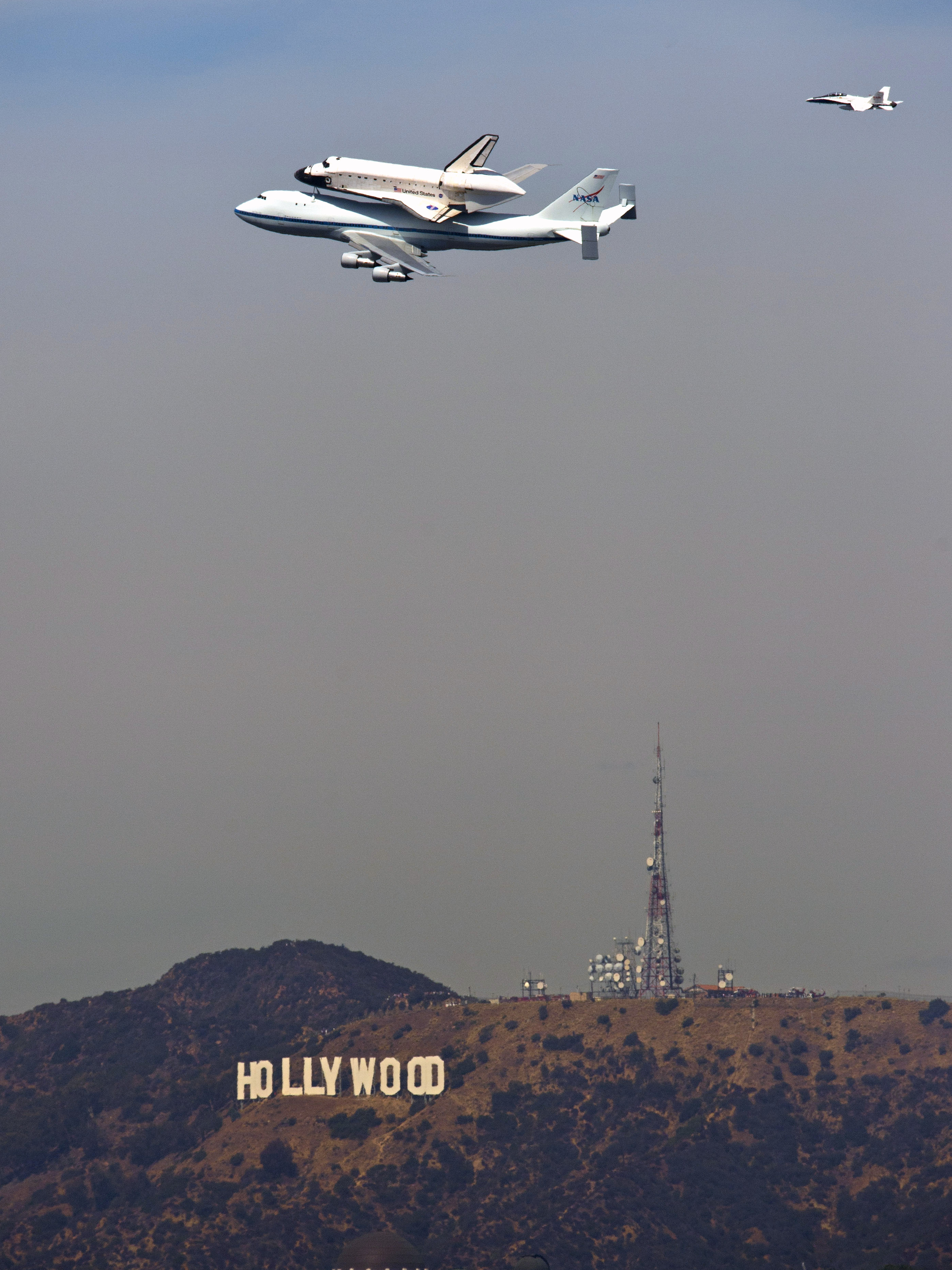The Space Shuttle Endeavour atop a modified 747 passes the Hollywood sign and the Griffith Observatory as seen from Dodger Stadium Friday.