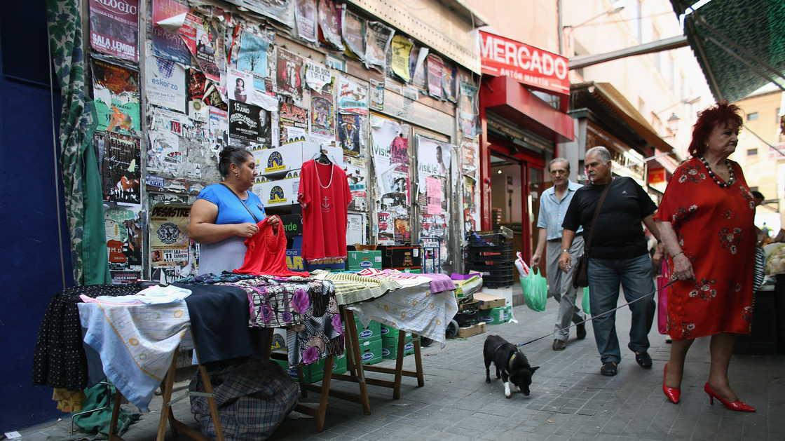Unemployment is rampant in Spain and full-time jobs are scarce. Here a woman works at a street stall in Madrid. Some Spaniards are signing up for "time banks," where individuals perform services based on their skills, and receive another service in return. No money changes hands. A woman is shown here working at a street stall in Madrid.